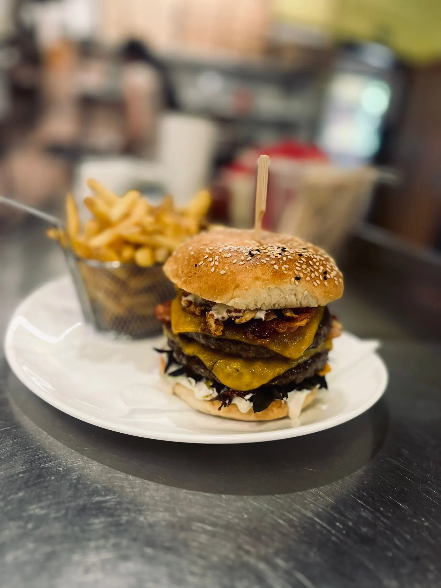 Vysoký double burger se slaninou, čedarem a křupavými bramborovými hranolky.