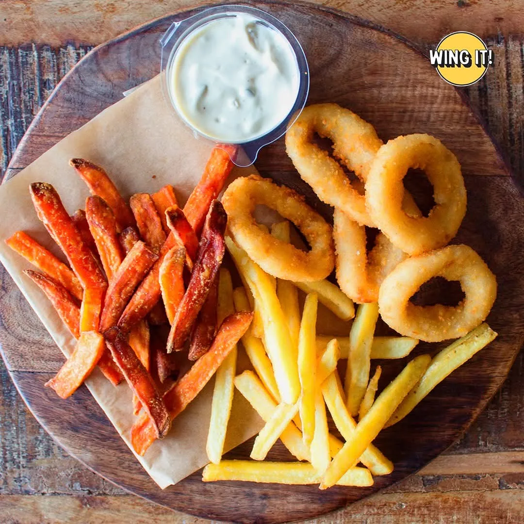 Výběr příloh: zlatavé hranolky, batátové hranolky a cibulové krouzky.